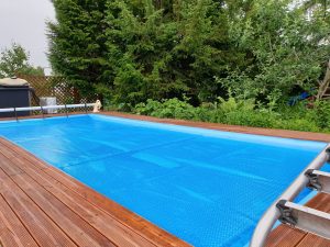 Photo of pool with a solar blanket to retain heat