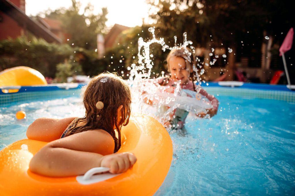 Two young girls splashing on floaties