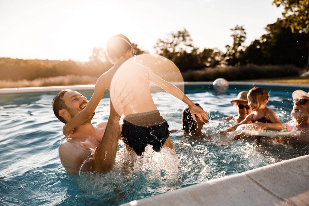 Man and boy splashing in a pool