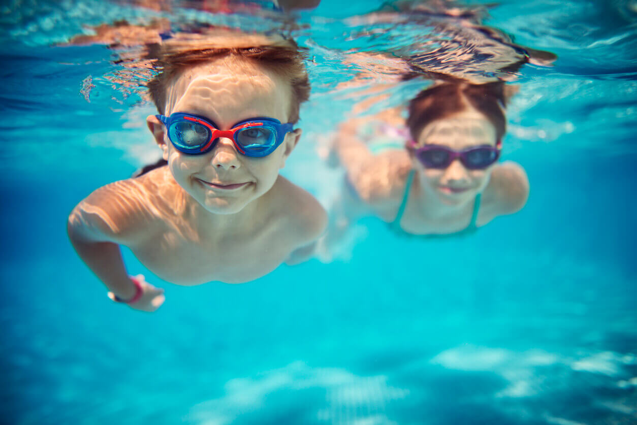 Kids swimming underwater with goggles on