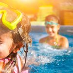 Girl with goggles on her head in pool
