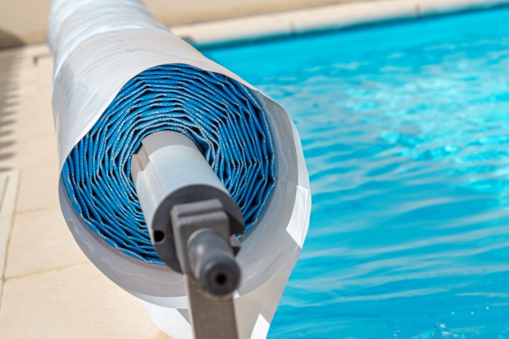 Pool cover on the edge of a pool during the summer