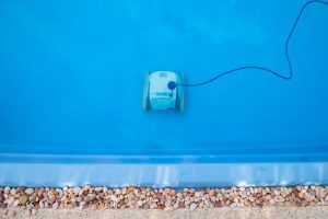 A photo of a robot pool cleaner at the bottom of a pool.